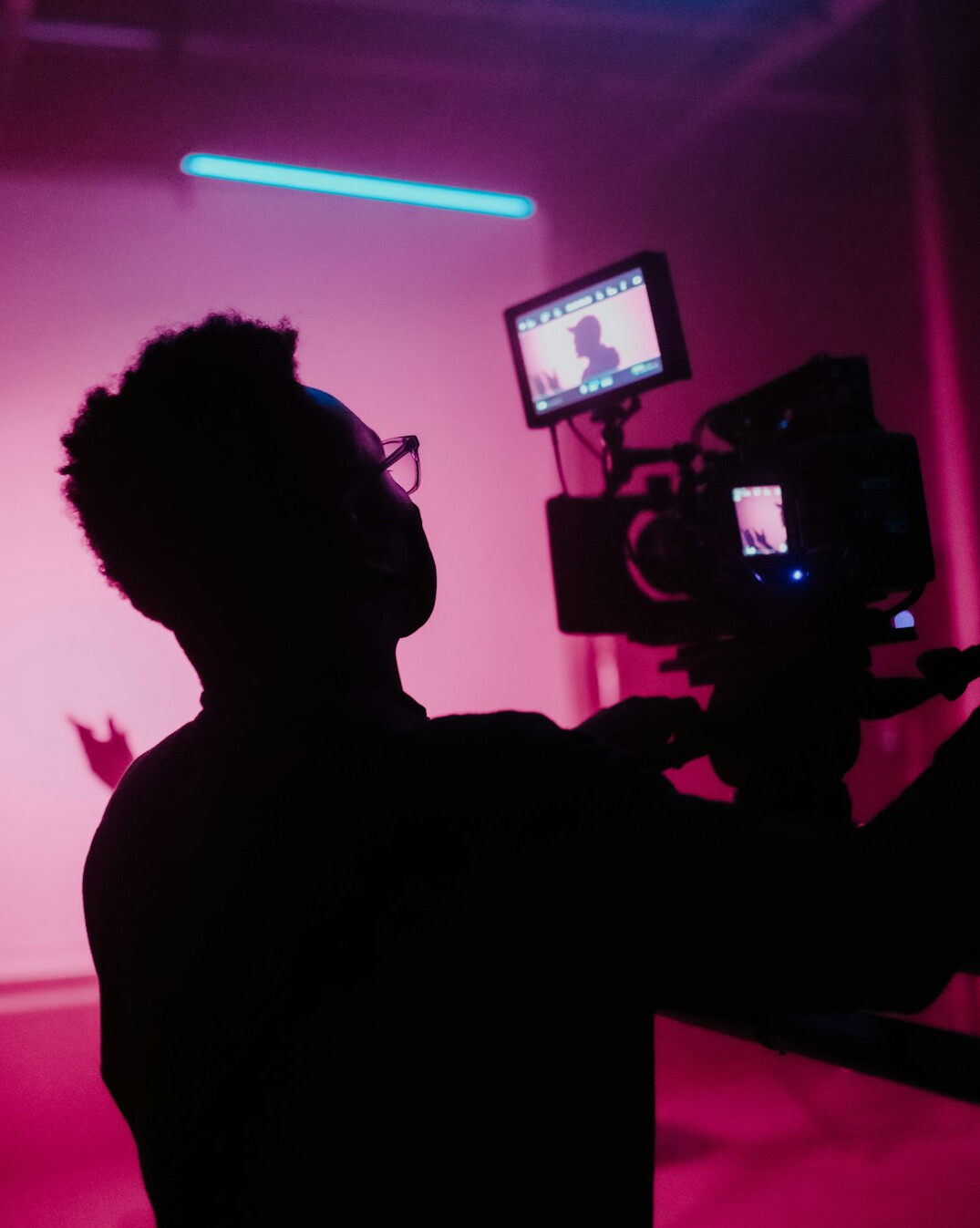 filmmaker adjusting camera on set
