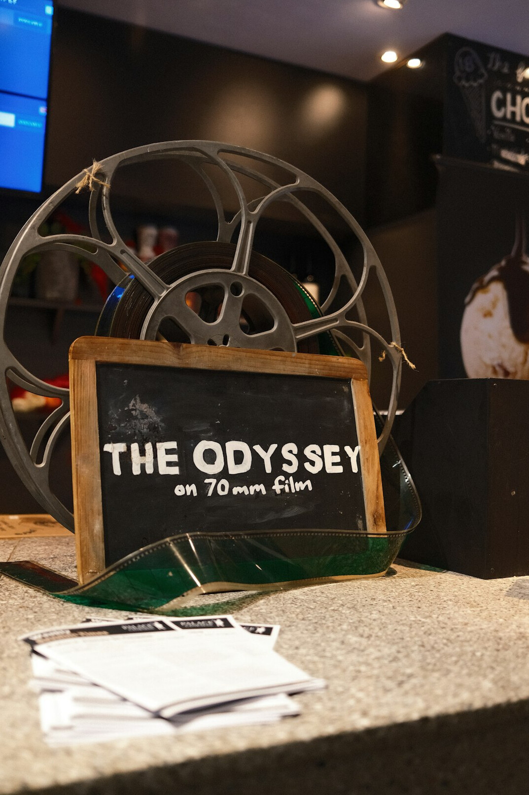 Film set clapperboard on a table with crew working in the background