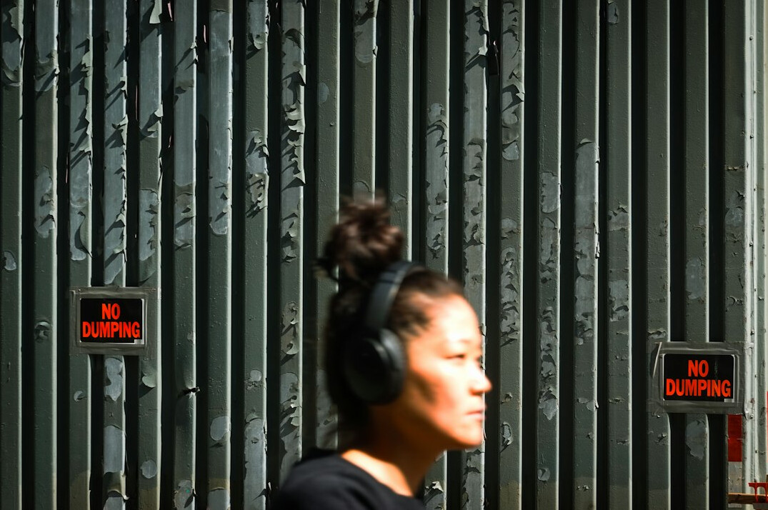 Portuguese woman editing video footage on a laptop with headphones